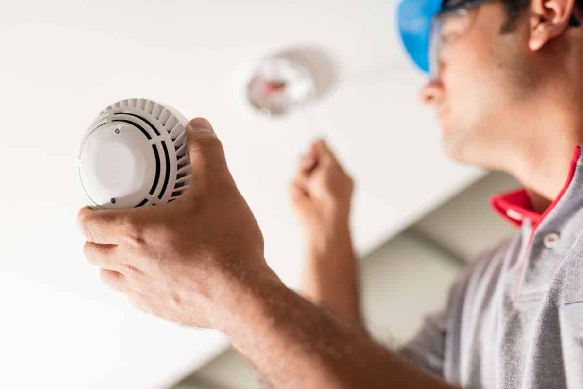 A ceiling smoke alarm being fitted